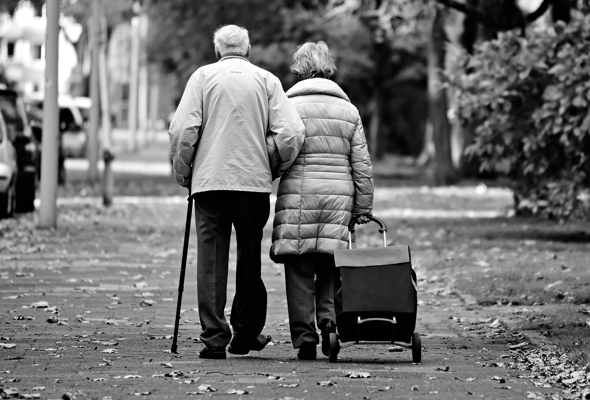 older couple seniors walking down road